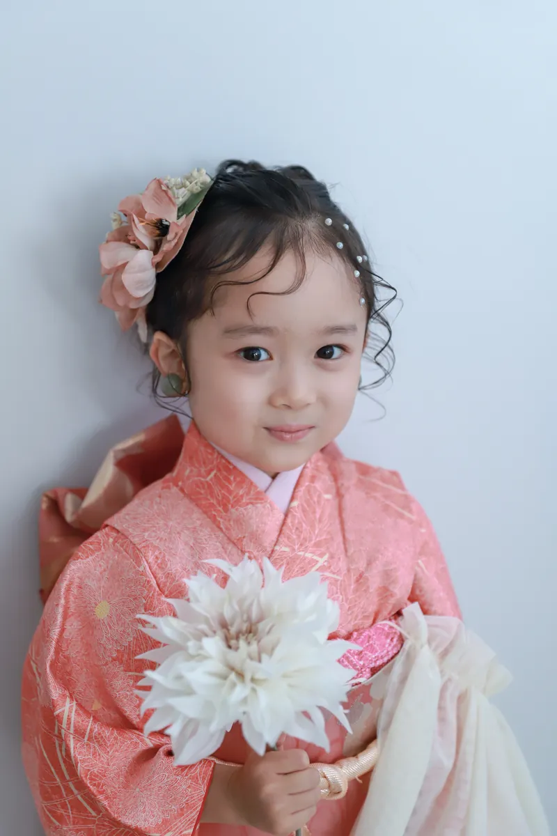 花を手にして笑う着物姿の女の子