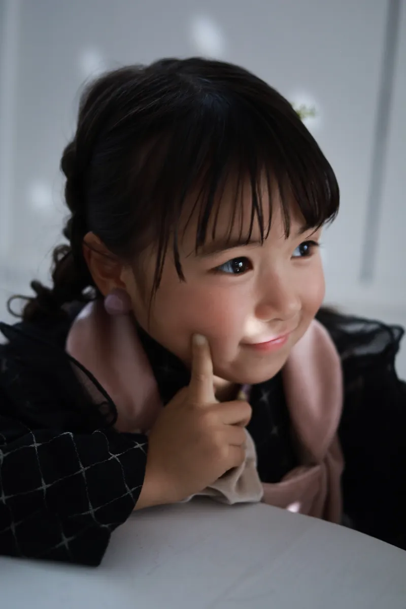 頬に指を当てて笑う被布姿の女の子